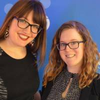 Two alumnae smile for a photo together